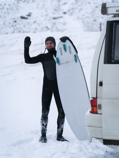 Zimowy surfer podróżujący z minivanem