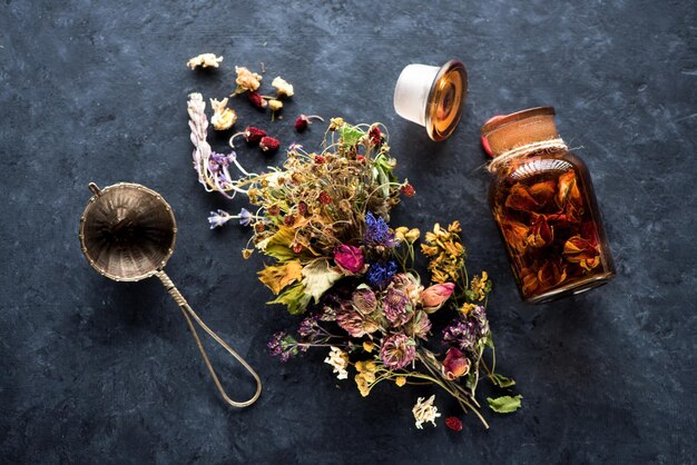 Zdjęcie zioła i kwiaty do ziołowej herbaty leczniczej na czarnym betonowym tle widok z góry