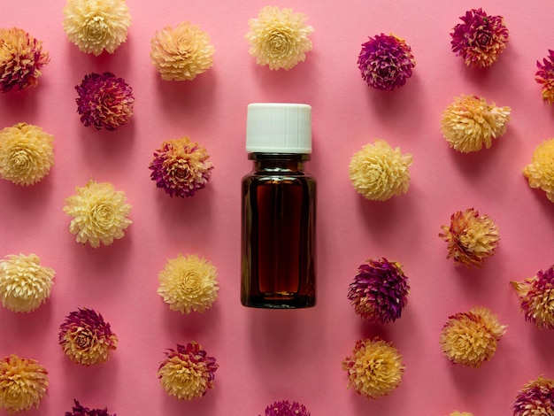 Ziołowy olejek szklana butelka makieta różowe kwiaty tło medycyna alternatywna pielęgnacja skóry spa aromaterapia