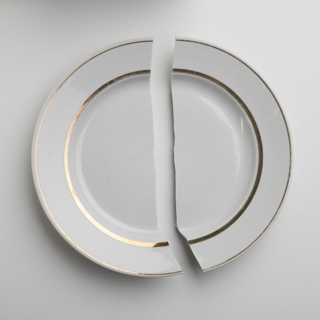 Złamany biały talerz porcelanowy na białym tle koncepcja brak jedzenia