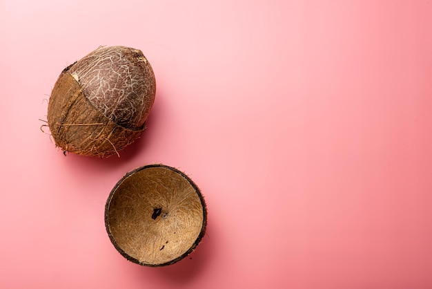 Złamany kokos na różowym tle Kokosowe czyszczenie