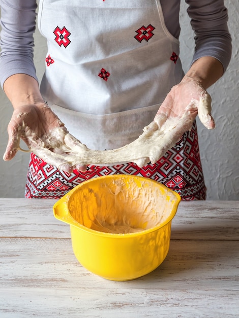 Złe ciasto. Katastrofa kuchenna i zła koncepcja gotowania. Zdenerwowana kobieta trzyma lepkie ciasto