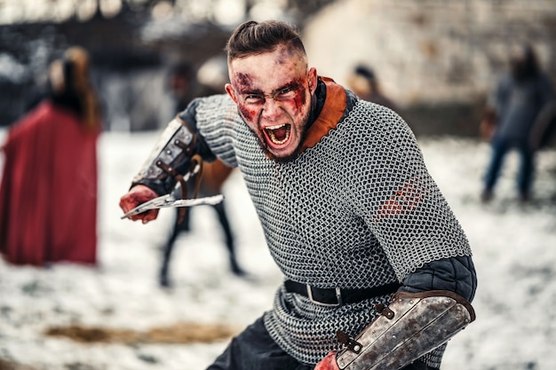 Zdjęcie złe emocje młodego wojownika, który idzie do walki z mieczem. bitwa pod zamkiem