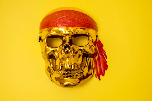 Złota czaszka z czerwoną opaską na żółtym tle Halloween piractwo Jolly Roger Znak piratów Zbrodnie rabunku Morscy złodzieje Baner Miejsce na tekst Kopiuj miejsce