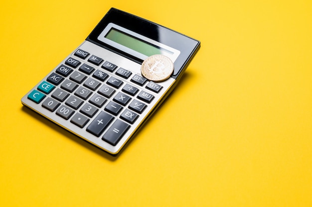 Złota moneta bitcoin na kalkulatorze