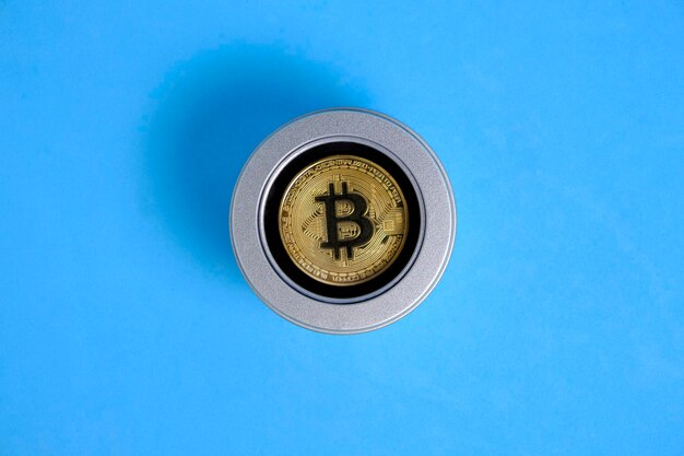 Złota moneta bitcoin w niebieskim tle pudełka