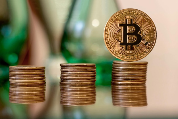Złota moneta nad stosem monet symbolizującym kryptowalutę bitcoin