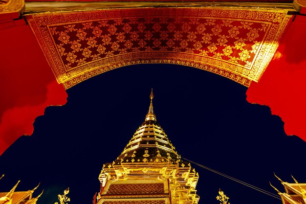 Złota pagoda i posąg Buddy w świątyni Wat Doi Suthep w nocy