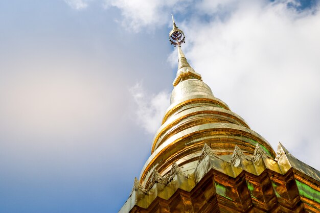 Zdjęcie złota pagoda jest oświetlona w świątyni ze świecącym słońcem.