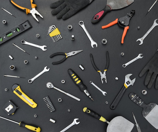 Złota rączka zestaw narzędzi na czarnym drewnianym stole Wiele kluczy i śrubokrętów, pilarek i innych narzędzi do wszelkiego rodzaju prac remontowych lub budowlanych Narzędzia mechanika
