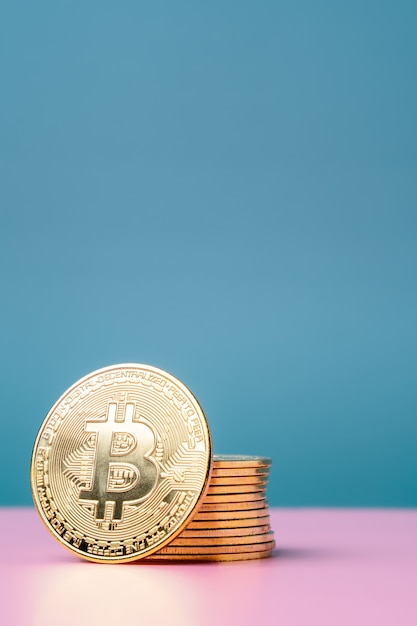 Zdjęcie złote bitcoiny na różowym i niebieskim tle. kryptowaluta i pieniądze.