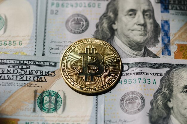 Złote błyszczące monety kryptowalut bitcoin na sto dolarów różnica między