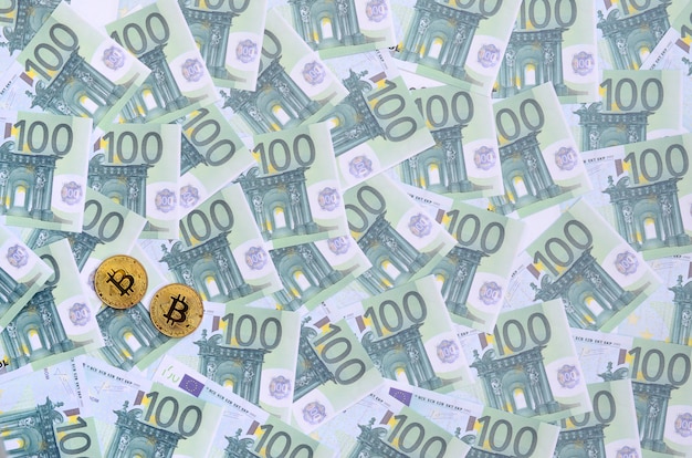 Złote Fizyczne Bitcoiny Leżą Na Zestawie Zielonych Nominałów Pieniężnych W Wysokości 100 Euro