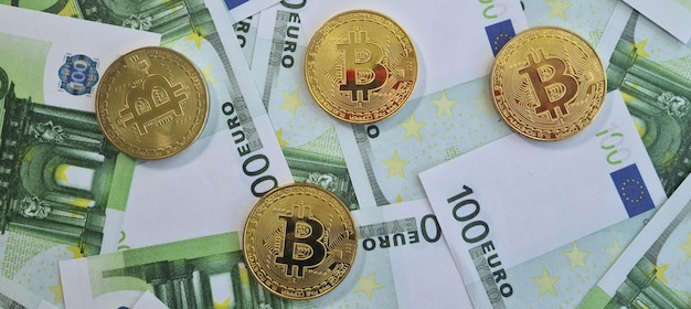 Złote monety bitcoin kryptowaluty na banknotach 100 euro