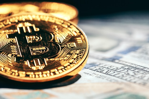 Złote monety bitcoin na pieniądze dolarów papierowych