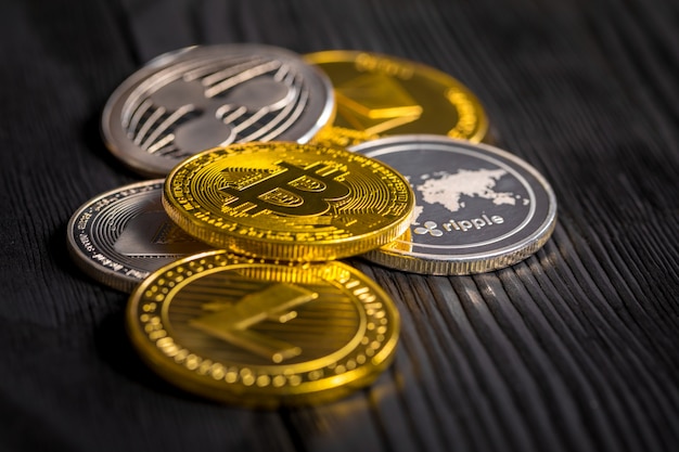 Złote monety z bitcoinem, na drewnie.