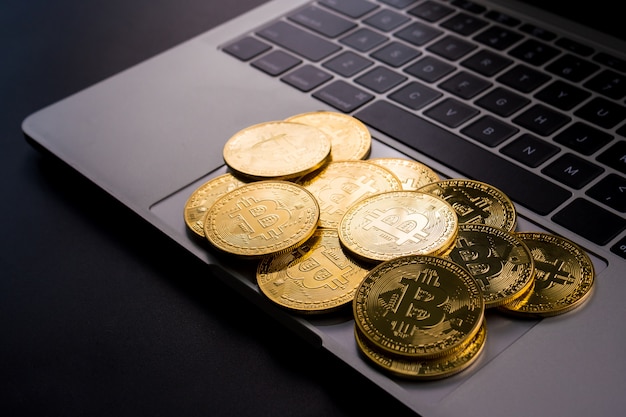 Złote monety z symbolem bitcoin na komputerze.