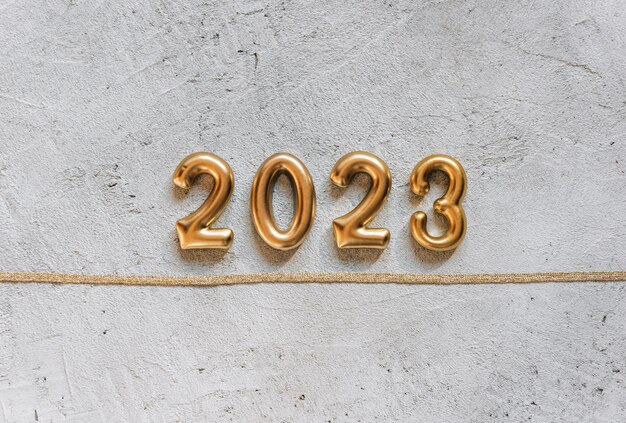 Złote numery 2023 na jasnym betonowym tle