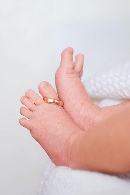 Złote obrączki na kciuk nogi małych dzieci na białym tle.