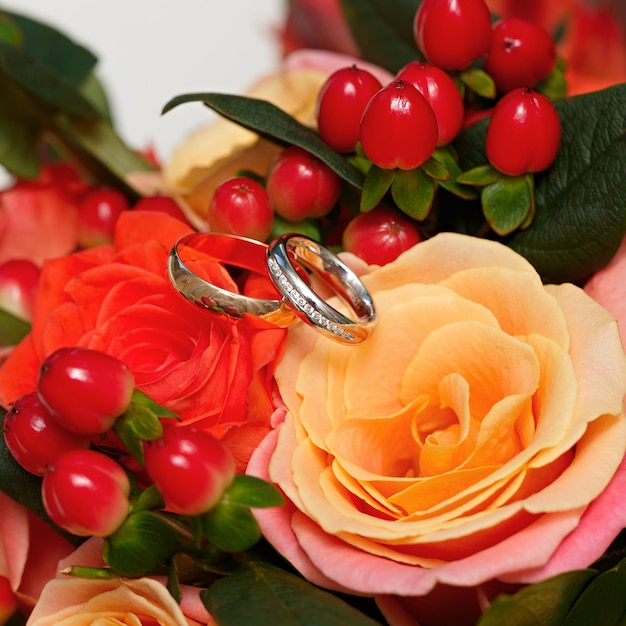 Złote obrączki ślubne na bukiecie kwiatów dla panny młodej