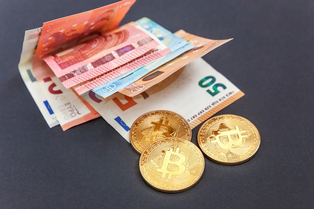 Złote symboliczne monety bitcoinów na banknotach euro