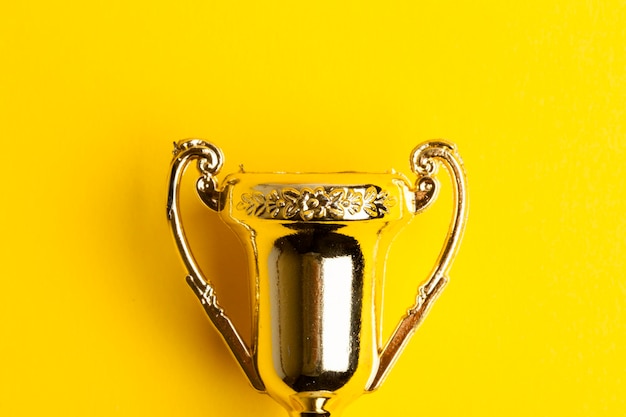Zdjęcie złote trofeum za osiągnięcie zwycięzcy na żółtym tle