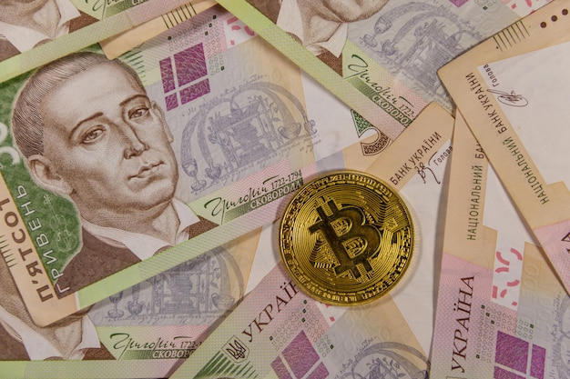 Złoty bitcoin na tle pięciuset ukraińskich hrywien