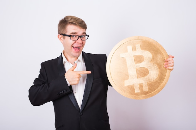 Złoty Bitcoin w dłoni mężczyzny, cyfrowy symbol wirtualnej kryptowaluty.