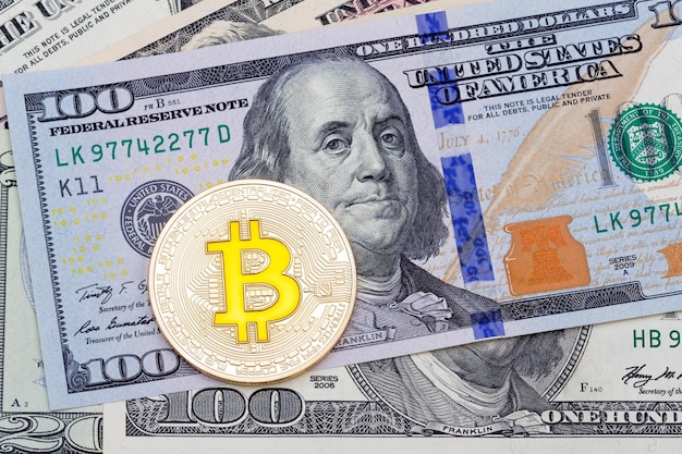 Złoty cruptocurrency żółty bitcoin na tle stu banknotów Zdjęcie w wysokiej rozdzielczości