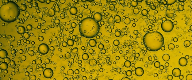 Złoty hyaluron Pęcherzyki olejowe serum kolagenowe lub żółte pęcherzyki olejowe kropla tekstura tła Płynne przezroczyste krople niezbędny produkt do pielęgnacji skóry z kropelami Bąbel syropu miodowego Krople olejowe z bliska