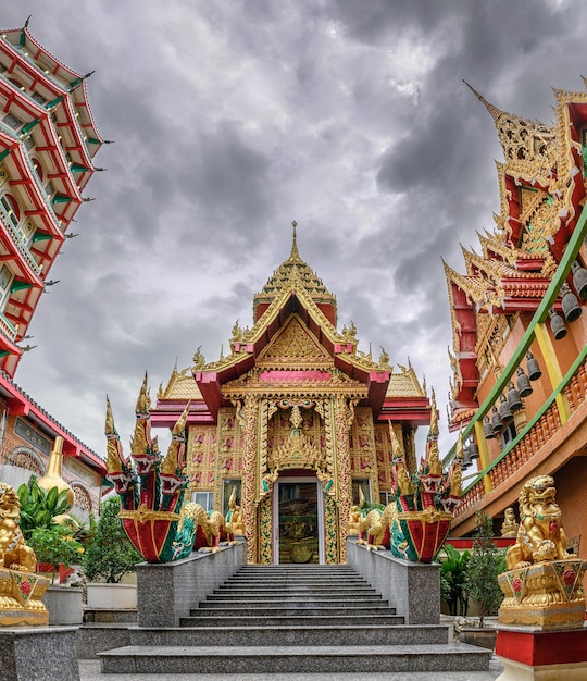 Złoty kościół z burzą na niebie wewnątrz świątyni Wat Tham Sua