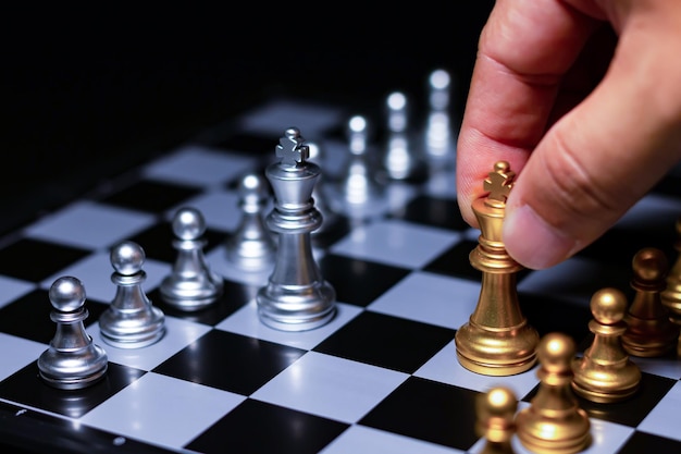 Zdjęcie złoty król szachowy prowadzi srebrne szachy w konkursie sukcesu biznesowego na szachownicypraca zespołowa