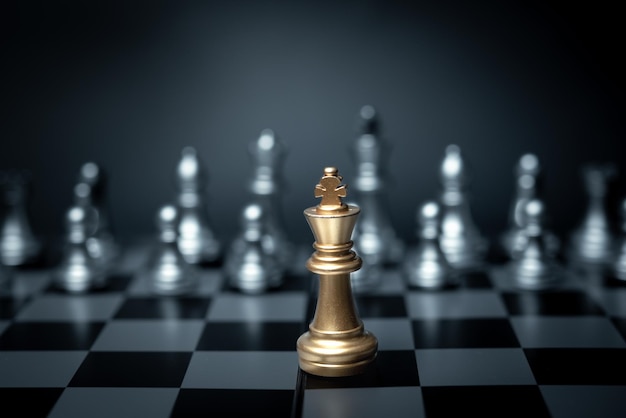 Złoty król szachowy stojący z przodu w grze planszowej Koncepcja strategii przywództwa biznesowego