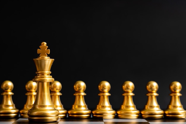 Zdjęcie złoty król szachy stoi przed pionkiem na czarno (koncepcja przywództwa, zarządzanie)