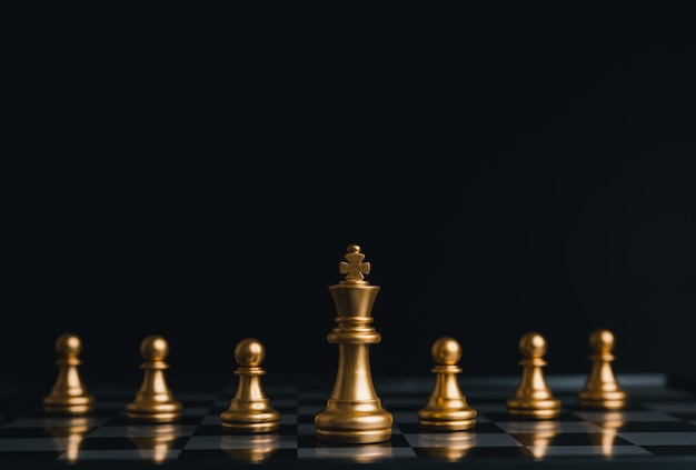 Złoty król zwycięzca obramowania ze srebrnymi szachami na szachowej grze planszowej koncepcja strategii