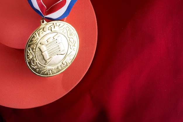 Złoty medal z chińskim znakiem oznaczającym nagrodę na czerwonym tle