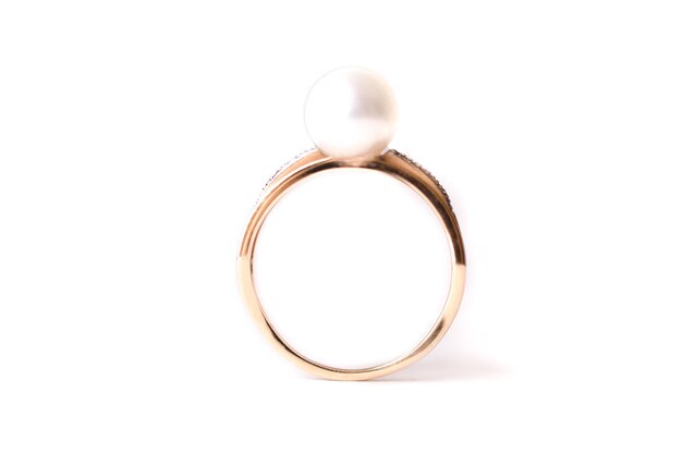 Złoty pierścionek z dużą perłą w dłoni dziewczyny na białym tle