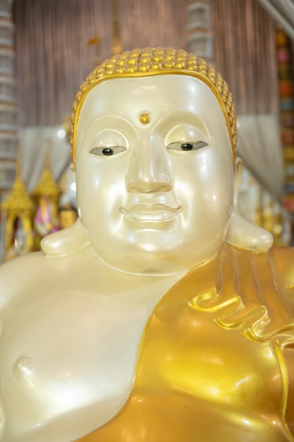 Złoty posąg Buddy na tle rzeźby