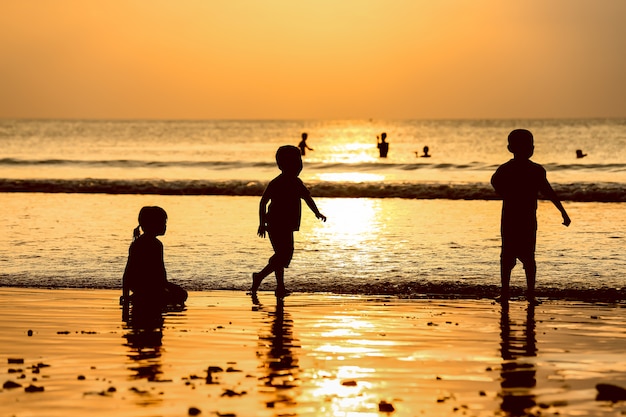 Złoty Zachód Słońca I Dzieci Lubią Bawić Się Na Plaży Z Promieniami Słońca