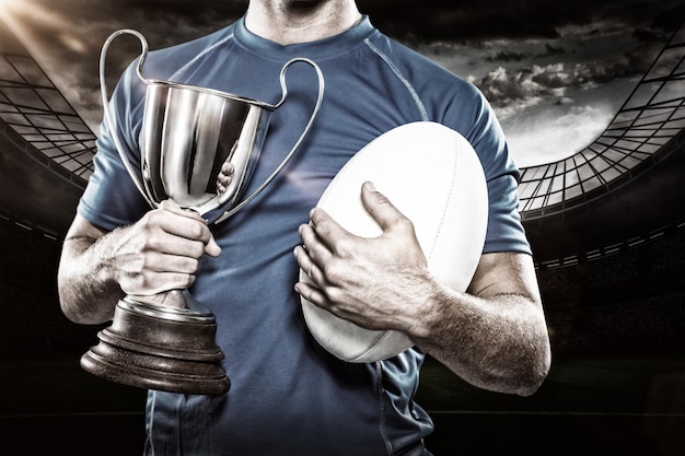 Złożony obraz 3D przedstawiający gracza rugby trzymającego trofeum i piłkę