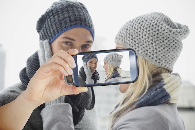 Zdjęcie złożony obraz dłoni trzymającej smartfona przedstawiający fotografię