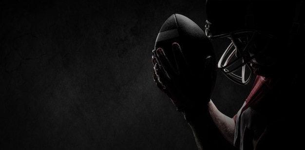Złożony obraz gracza futbolu amerykańskiego stojącego w kasku rugby i piłce