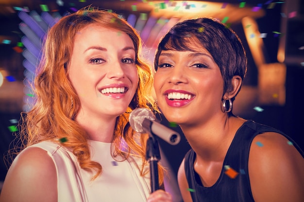 Złożony obraz koleżanek śpiewających razem w barze