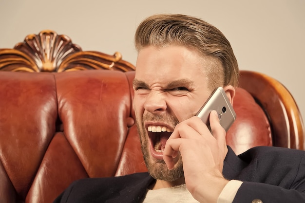 Zły szef Człowiek zadbany krzyczeć agresywnie telefon komórkowy szary tło Biznesmen zły połączenie telefon komórkowy Połączenie połączenia komórkowego Facet przystojny atrakcyjny pracownik biurowy mówić telefon komórkowy