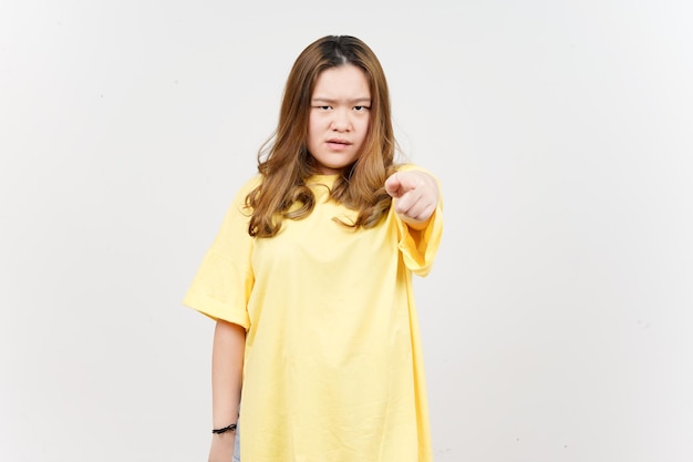 Zły wyraz twarzy i wskazujący na aparat pięknej azjatyckiej kobiety ubranej w żółtą koszulkę