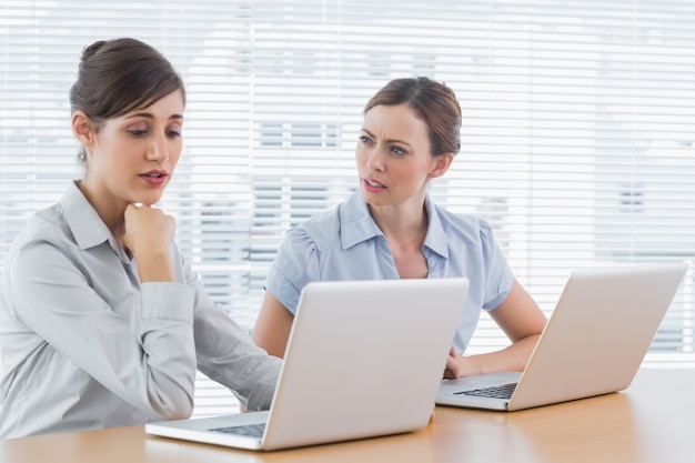 Zmartwiony businesswomen pracy na laptopach