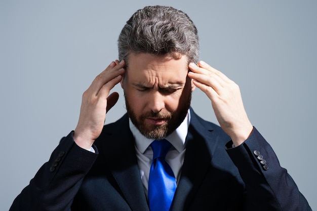 Zmęczenie bólem głowy i stres Biznesowy mężczyzna w garniturze jest zmęczony migreną bólu głowy Ból głowy