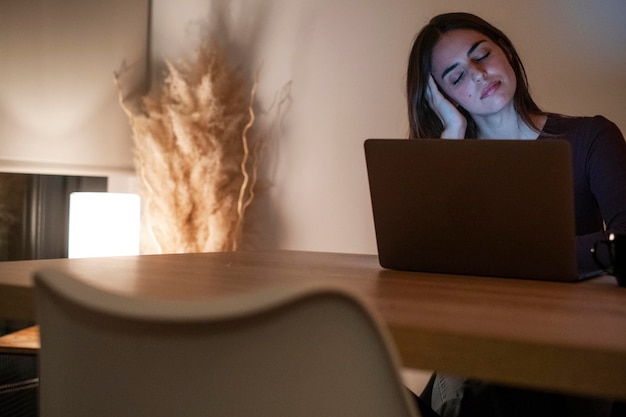 Zdjęcie zmęczona bizneswoman pracująca na komputerze do nocy portret zestresowanej przypadkowej kobiety z bólem głowy przy biurku wyczerpana bizneswomen pracująca późno w nocy na laptopie w biurze lub w domu