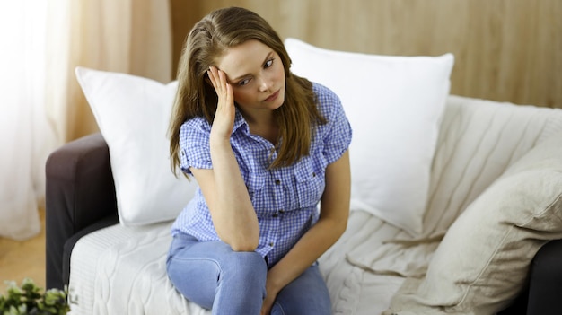 Zdjęcie zmęczona zdenerwowana kobieta martwi się zmęczeniem pracą domową i kwarantanną samoizolacji z powodu koronawirusa covid-19.