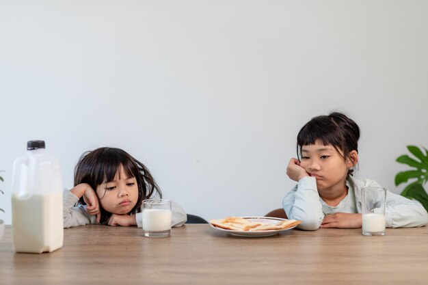 Zmęczone rodzeństwo dziewczyny zasnęły przy śniadaniu